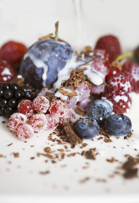 Closeup view of mixed berries with chocolate shavings and milk — Stock Photo