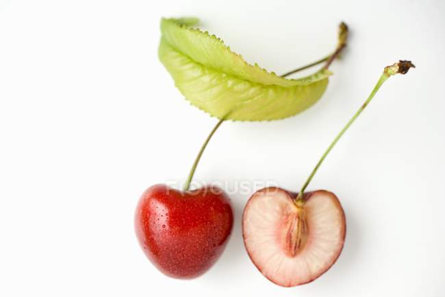 Fresh halved cherry with leaf — Stock Photo