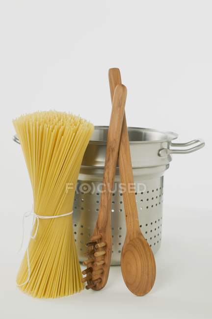 Spaghetti with pan and wooden spoon — Stock Photo
