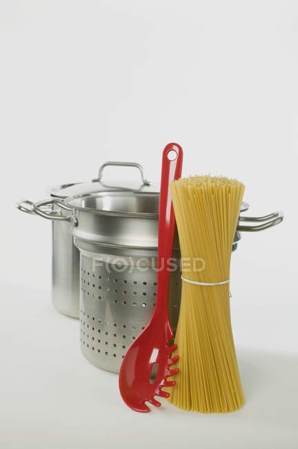 Espaguetis con sartenes y servidor - foto de stock
