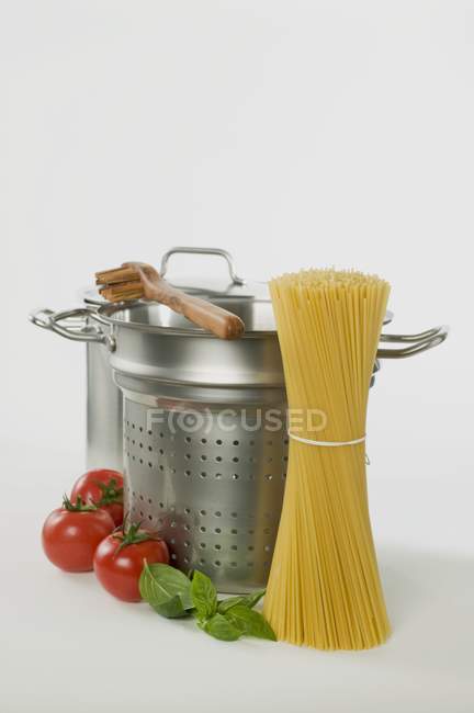 Espaguetis con sartenes y servidor - foto de stock