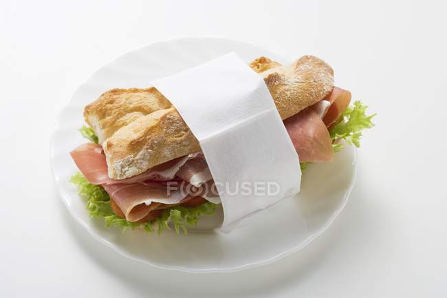 Sanduíche de presunto cru em guardanapo de papel — Fotografia de Stock