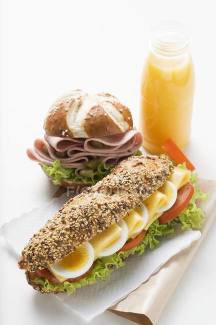 Sandwich, Wurst in Laugenrolle und Saft — Stockfoto
