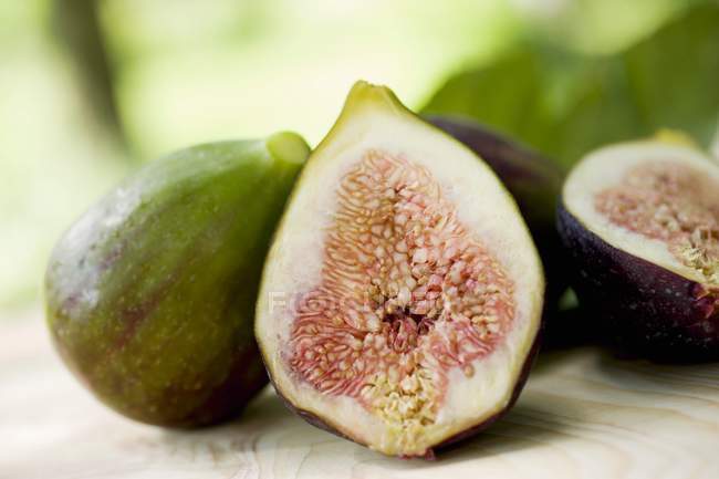 Whole and one halved figs — Stock Photo