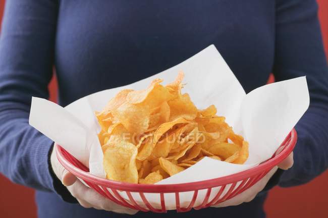 Frau hält Korb mit Chips — Stockfoto