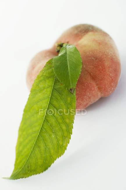 Reifer Pfirsich mit Blatt — Stockfoto