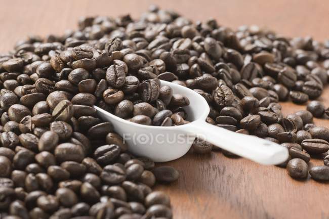 Granos de café tostados con cucharada - foto de stock