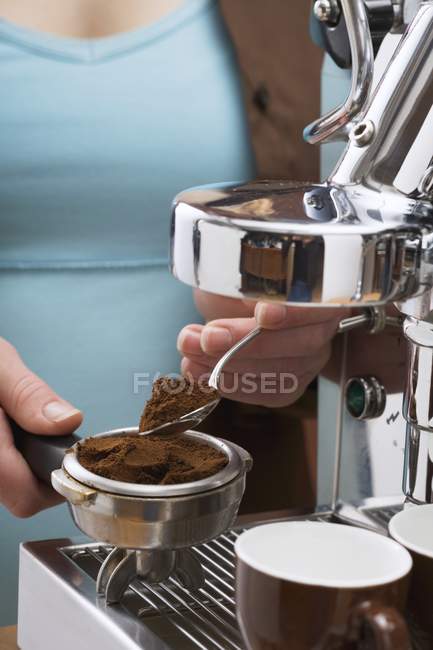 Vista de perto da mulher colocando pó de café para filtro de máquina de café expresso — Fotografia de Stock