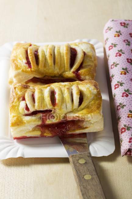 Closeup view of two raspberry turnovers with spatula on plate — Stock Photo