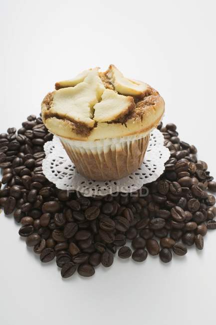Muffin on a heap of coffee beans — Stock Photo
