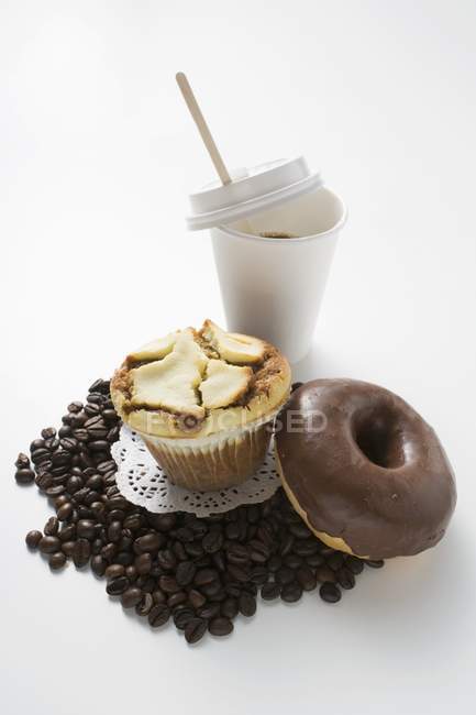 Muffin, rosquillas y granos de café - foto de stock