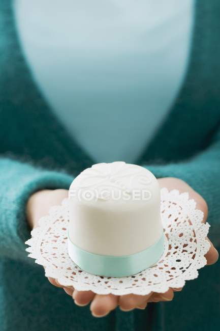 Petit gâteau blanc sur un napperon — Photo de stock
