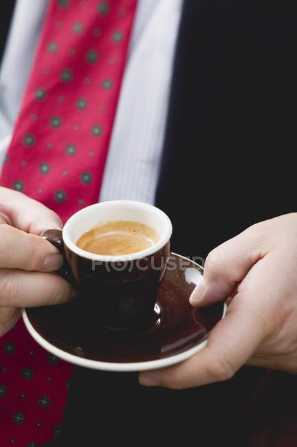 Vista de perto do homem de terno e gravata segurando xícara de café expresso — Fotografia de Stock