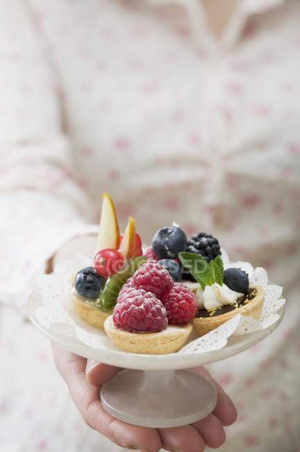 Woman holding berry tarts — Stock Photo