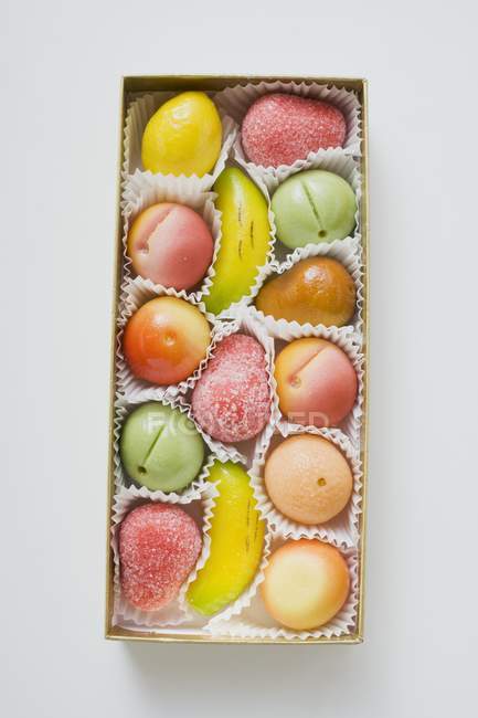 Вид зверху на марципанові фрукти в шоколадній коробці — стокове фото
