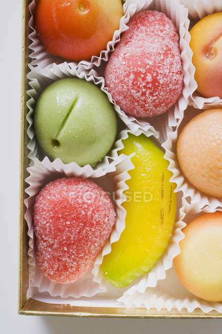Closeup top view of Marzipan fruits in chocolate box — Stock Photo