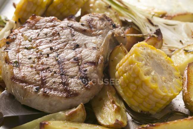 Pork chop on roasted potatoes — Stock Photo