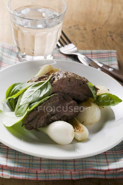 Roasted beef with spring onions and basil — Stock Photo