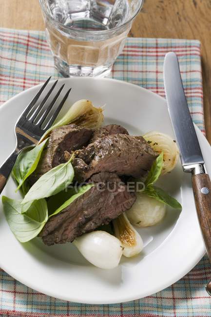 Roasted beef with spring onions and basil — Stock Photo