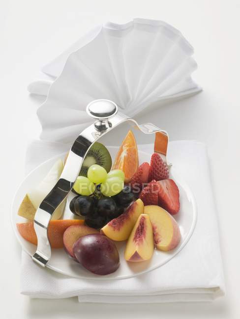Fresh sliced fruits on serving dish — Stock Photo