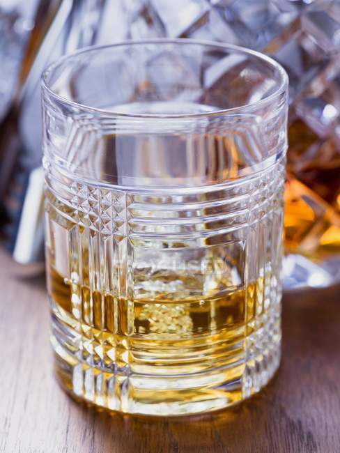Closeup view of Whisky in glass on wooden surface — Stock Photo