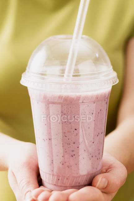 Hands holding smoothie — Stock Photo