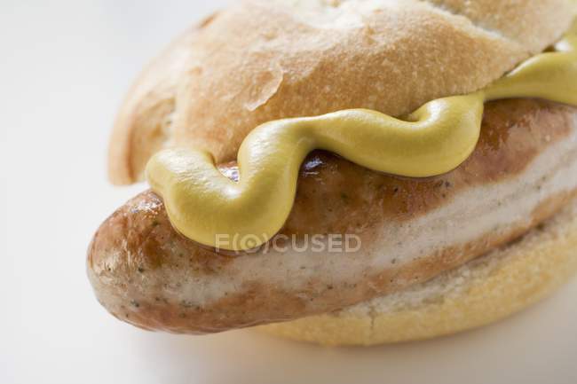 Bratwurst mit Senf im Brötchen — Stockfoto