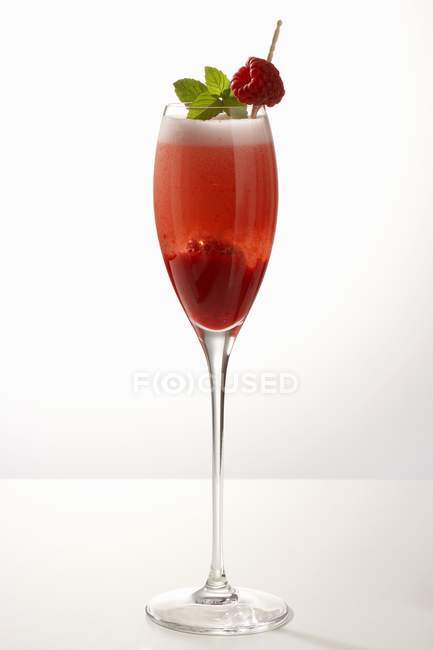 Крупный план красного напитка с малиной и листьями мяты в стекле — стоковое фото