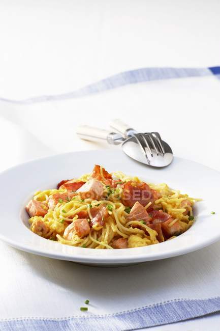 Espaguetis carbonara con salmón frito - foto de stock