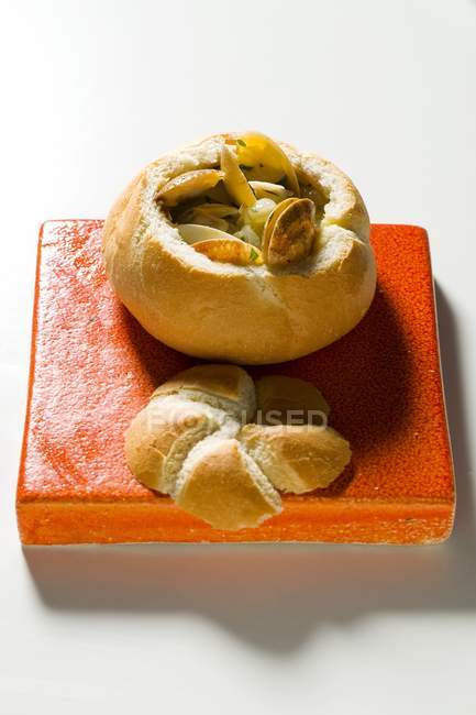 Rotolo di pane ripieno di vongole sulla scrivania rossa — Foto stock