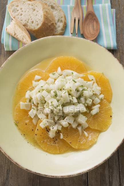 Салат из фенхеля на оранжевых ломтиках на белой тарелке — стоковое фото