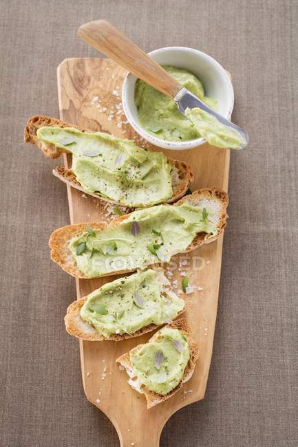 Bruschetta con avocado spalmato sul tagliere — Foto stock