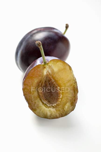 Whole and halved damsons — Stock Photo