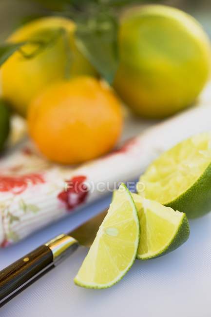 Cunhas de limão e metade espremida — Fotografia de Stock