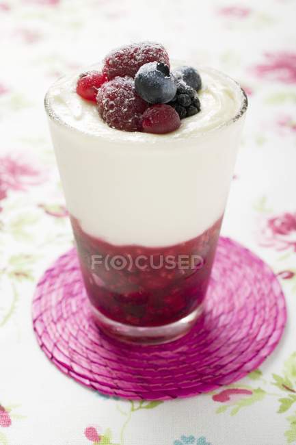 Крупним планом фруктовий десерт з ванільним кремом і ягодами в склі — стокове фото
