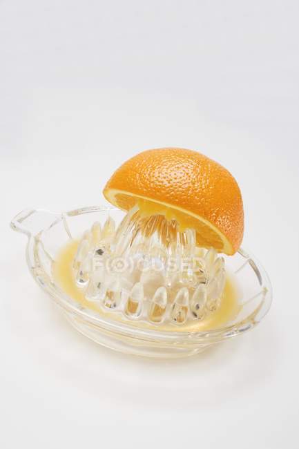 Half orange on citrus squeezer — Stock Photo