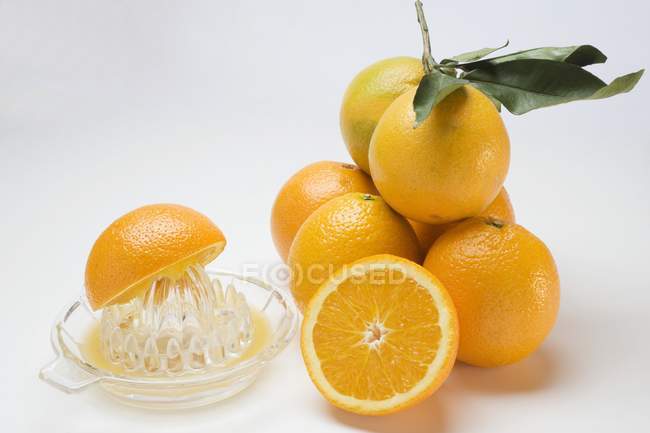 Naranjas frescas y exprimidor de cítricos - foto de stock