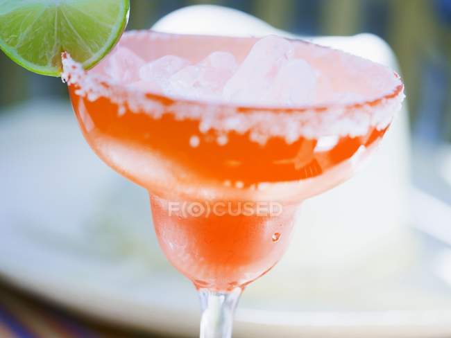 Lime cocktail in orange glass — Stock Photo