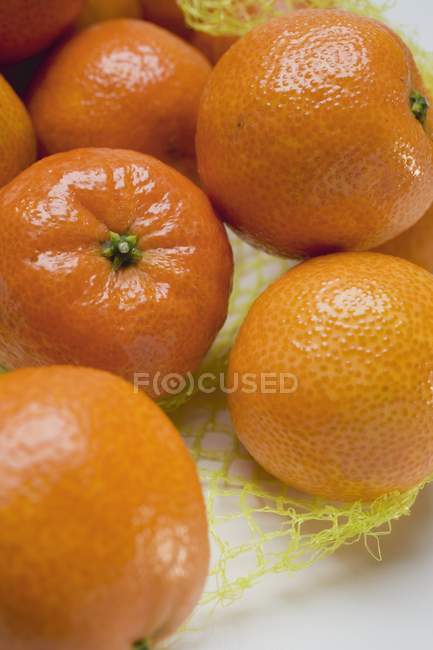 Fresh ripe clementines in net — Stock Photo