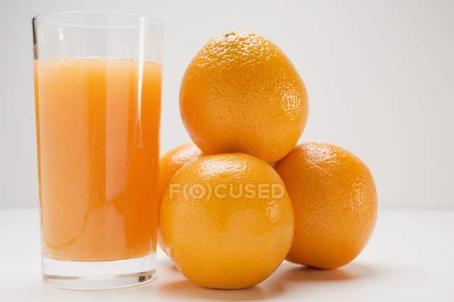 Glass of fresh juice with oranges — Stock Photo