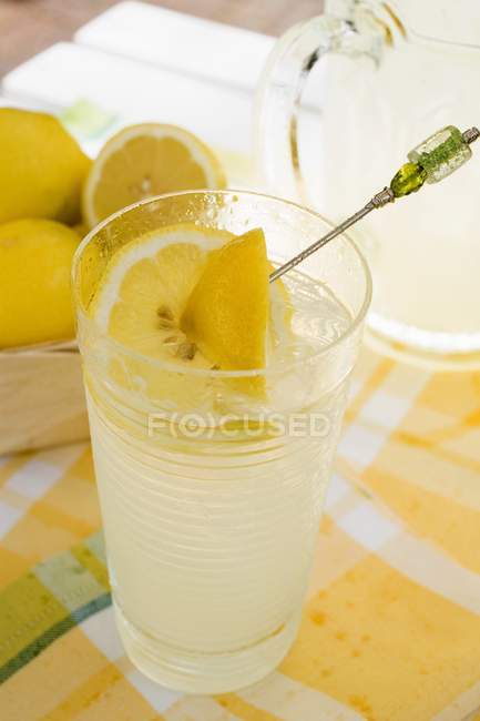 Citronnade en verre avec des citrons frais — Photo de stock