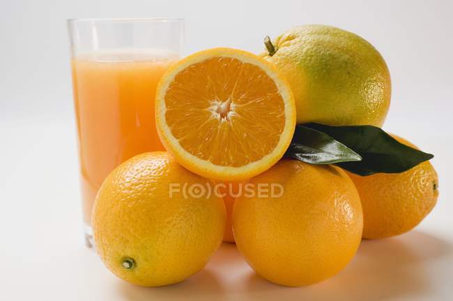 Bicchiere di succo fresco con arance — Foto stock