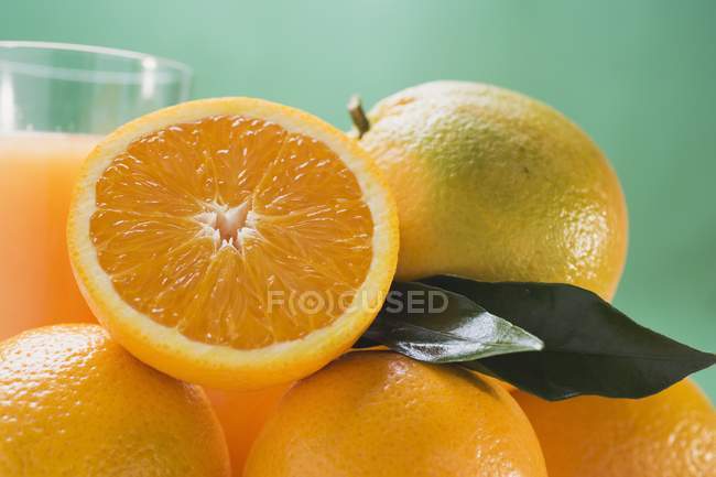 Vaso de jugo fresco con naranjas - foto de stock