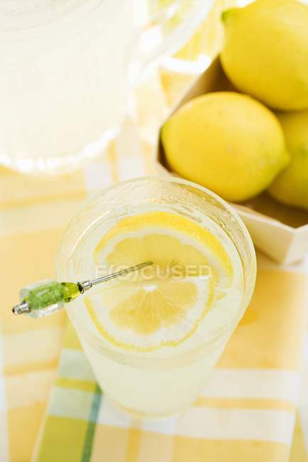 Lemonade in glass with fresh lemons — Stock Photo