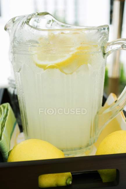 Lemonade in jug with slices of lemon — Stock Photo