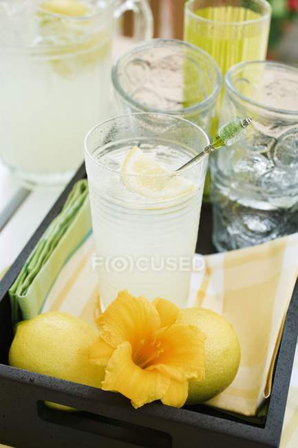 Lemonade in glass with flower — Stock Photo