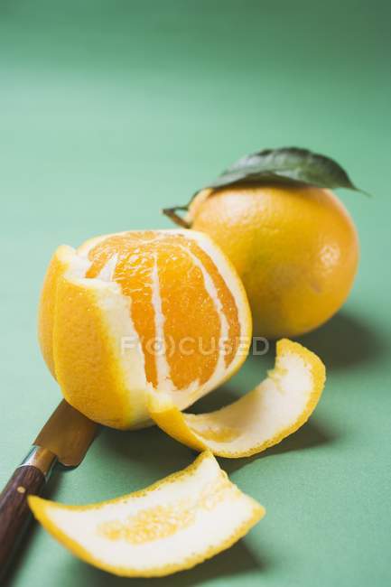 Peeled and unpeeled fresh oranges — Stock Photo