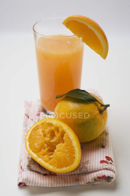 Verre de jus frais et d'oranges — Photo de stock