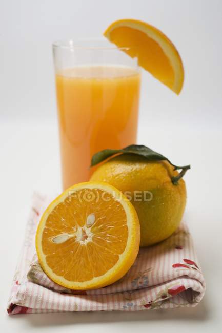 Bicchiere di succo fresco e arance — Foto stock