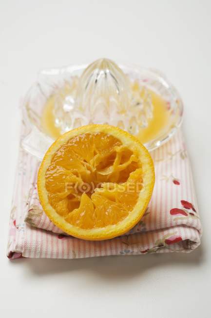 Orangenhälfte und Zitruspresse — Stockfoto